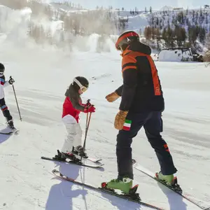 Crianças em aula de esqui com um professor.