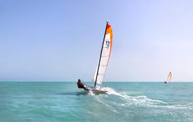 homem praticando surfe a vela no mar