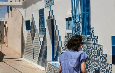 mulher de costas e parede de azulejos azuis