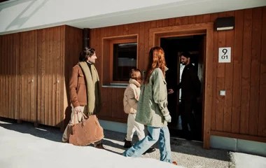 concierge recebendo família em chalé na neve