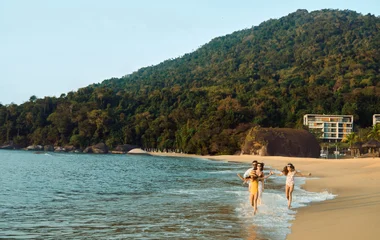 família caminhando na praia