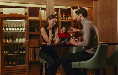 casal comendo fondue com queijos e vinhos