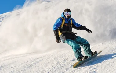 Homem praticando snowboard.