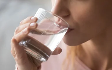 Foco em uma mulher bebendo copo de água