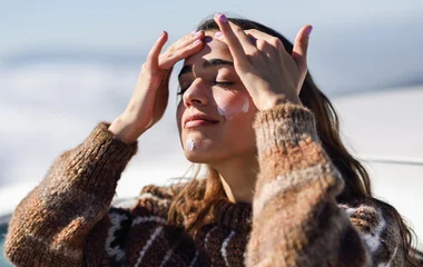 Mulher passando protetor solar facial