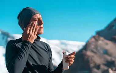 Homem passando protetor solar no rosto