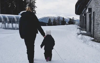 mom with young child walking in the snow