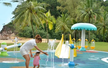 Woman and baby holding hands in a baby pool