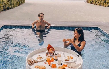 Couple enjoying breakfast in the pool