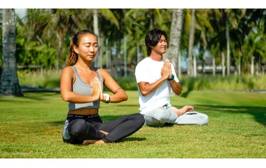 Man and woman doing yoga outdoors