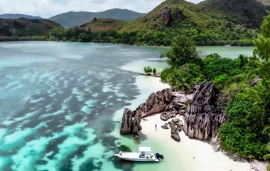 Drone shot overlooking a catamaran situated on the edge of the Seychelles island