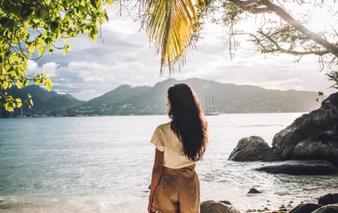 Woman at the beach looking at the Indian Ocean which surrounds the Seychelles island