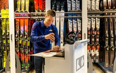 A man fixing some skis in a ski shop