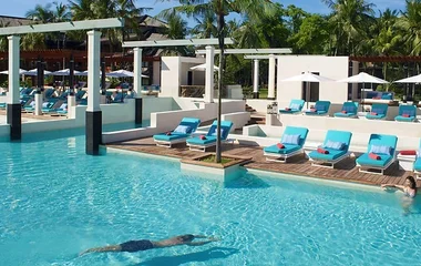 A couple swimming in Club Med high end pool resort