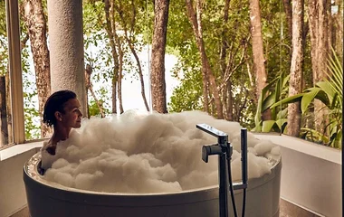 woman having bubble bath in tub in club med