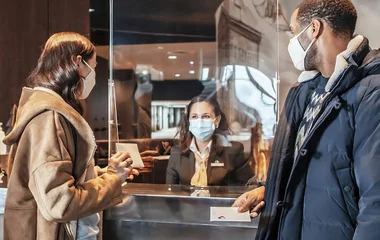 A man and a woman walking on a beach with palm trees