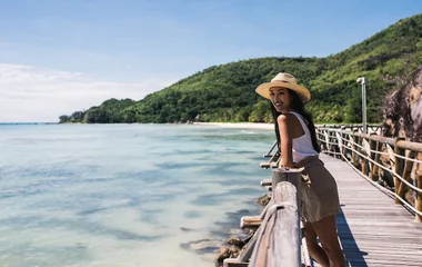 Ragazza che ammira il mare turchese dalle passerelle delle Seychelles durante una giornata di sole tropicale