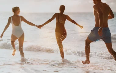 Personen laufen am Strand