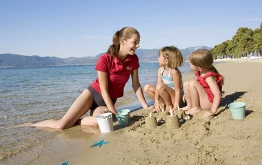 Famiglia che gioca in spiaggia al Resort Gregolimano, tra mare cristallino e natura incontaminata in Grecia