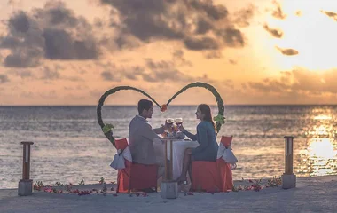 Una coppia che si gode un drink in riva al mare