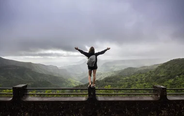 Frau blickt auf ein Regenwald Panorama