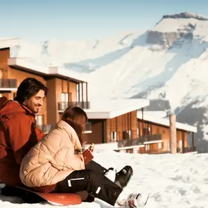child and father sitting on the ski slopes