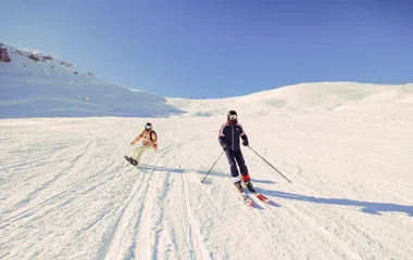 two skiers skiing down the slopes