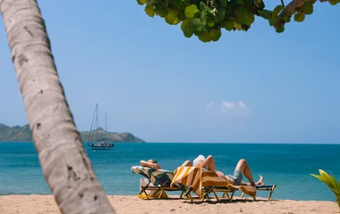 Pareja en reposeras en la playa.