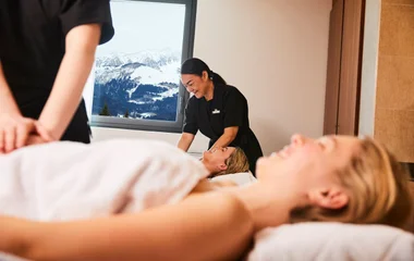 Dos mujeres en el spa del resort, recibiendo masajes.