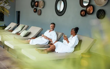 Um homem e uma mulher, de roupão sentados em cadeiras