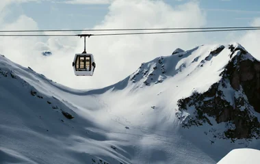 Teleférico com vista de fundo de montanha coberta de neve.