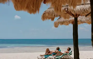 Casal deitado em espreguiçadeiras.