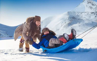 Adulto e criança se divertindo na neve