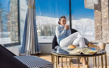 Mulher tomando café da manhã nos Alpes.