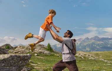 Pai e filho se divertindo no topo de uma motanha.