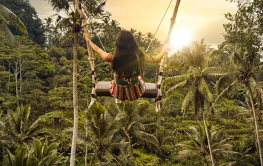 Femme jouant à la balançoire au-dessus des rizières de Tegalalang à Bali