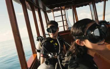 Mann und Frau auf Boot mit Schnorchelausrüstung