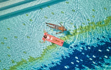 Criança e avô relaxando na piscina