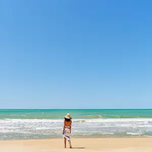 Mulher de costas olhando o mar.