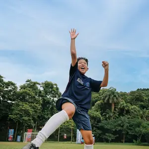 criança comemorando uma vitoria no futebol