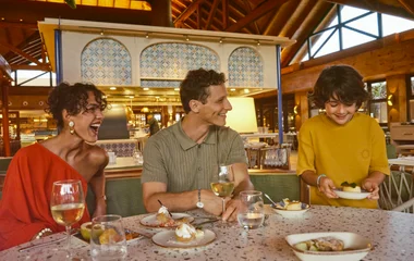 Família sorridente sentada à mesa com suas sobremesas no restaurante premium