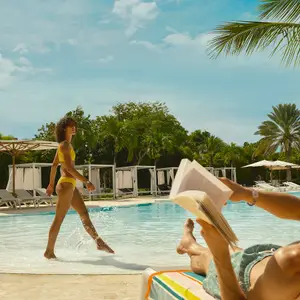 Homem e mulher na piscina do resort.
