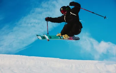 Pessoa no ar enquanto salta durante esporte de neve.