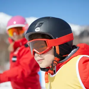Criança com roupa e óculos para praticar esporte na neve.