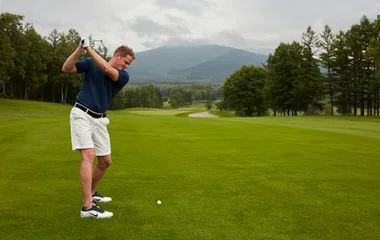 Golfista se preparando para bater na bola de golfe.