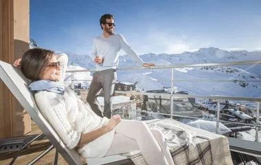 Pareja tomando el sol en el balcón de la suite.
