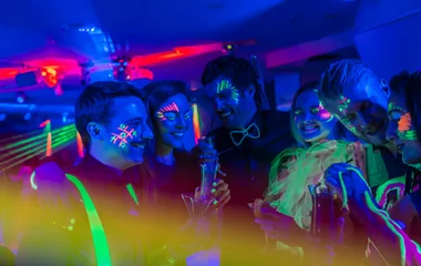 Pessoas com o rosto pintado com luz fluorescente.