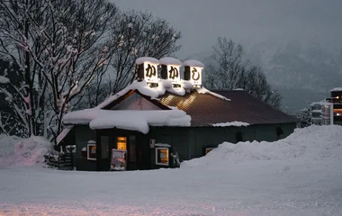 Snow-covered restaurant in snowy winter evening in Niseko, Hokkaido. Charming seasonal scene.