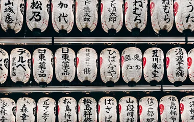 Detailed view of traditional Japanese paper lanterns with kanji characters, creating a cultural ambiance.