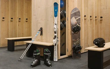 Dressing room with ski and snowboard equipment.